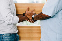 Men Shaking Hands at Entrance of Home  image 1