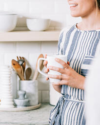 Woman Holding Cup of Coffee and having Conversation in the Kitchen  image 4