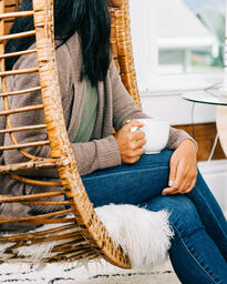 Woman Holding Cup of Coffee and Engaging in Conversation at Small Group  image 3