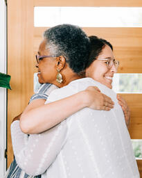 Women Hugging at Entrance of Home before Small Group  image 3