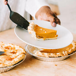 Woman Serving Up Slice of Pumpkin Pie  image 2
