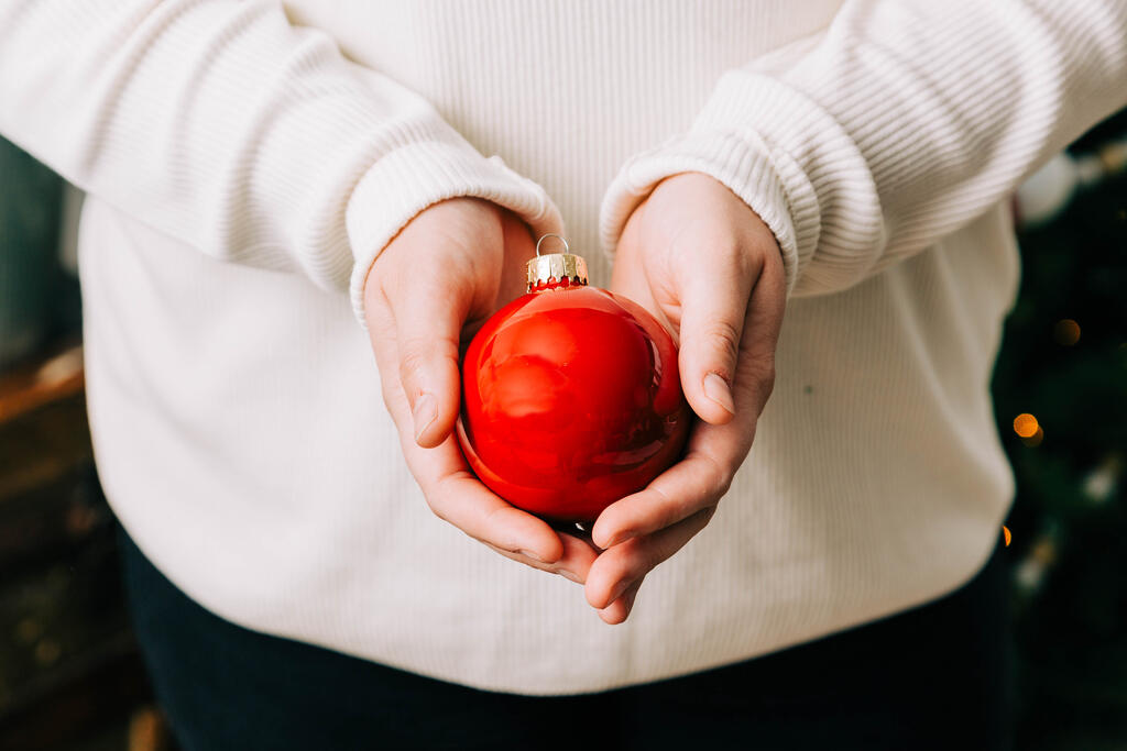 Woman Holding a Red Christmas Ornament large preview