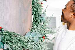 Man Decorating for Christmas with Garland  image 1