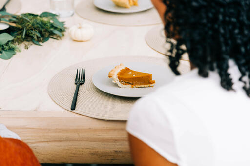 Woman Seated at Table for Thanksgiving Dessert