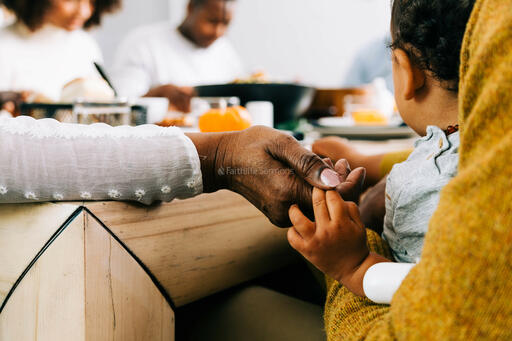 Grandmother and Baby Holding Hands in Prayer Before the Thanksgiving Meal