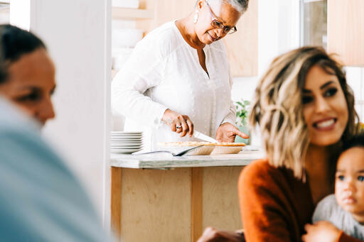 Grandmother Slicing and Serving Pie in the Kitchen