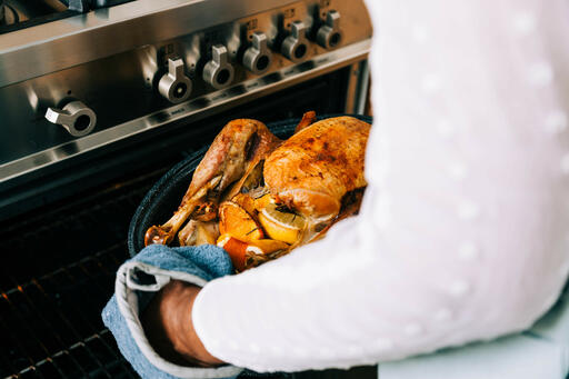 Woman Pulling Thanksgiving Turkey out of the Oven