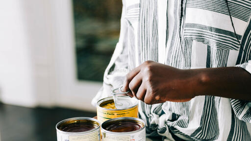 Woman Opening Up Canned Food Items