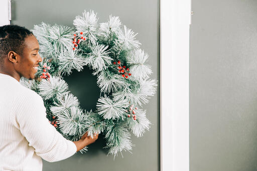 Man Putting a Wreath on the Door for Christmas
