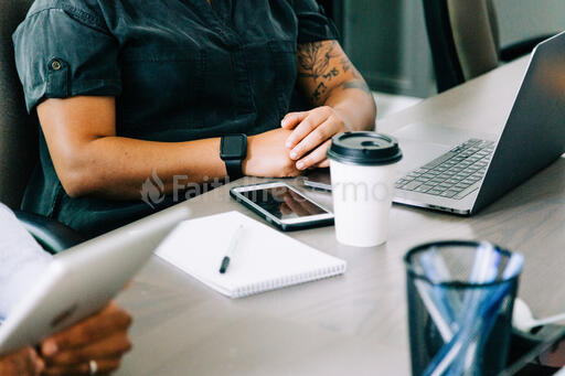 Woman Seated at Conference Table with Laptop Open During Meeting