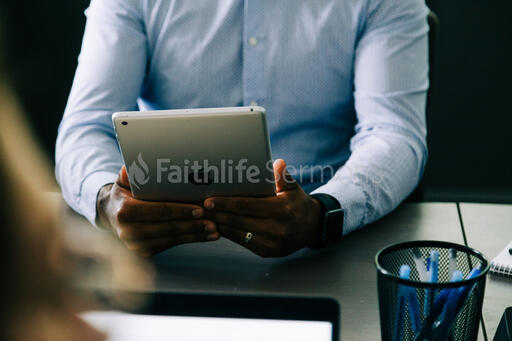 Man Using an iPad During a Meeting