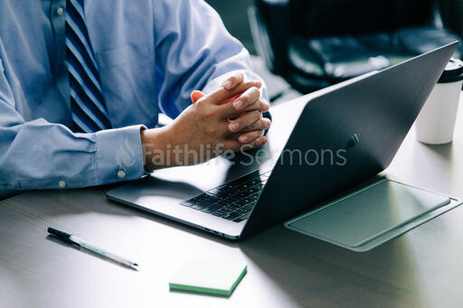 Man with Hands Folded at Desk