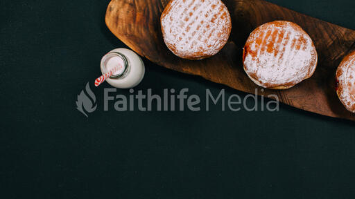 Jelly donut on wood with milk