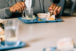 Man Eating at a Community Meal  image 1