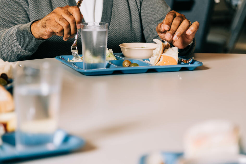 Man Eating at a Community Meal large preview