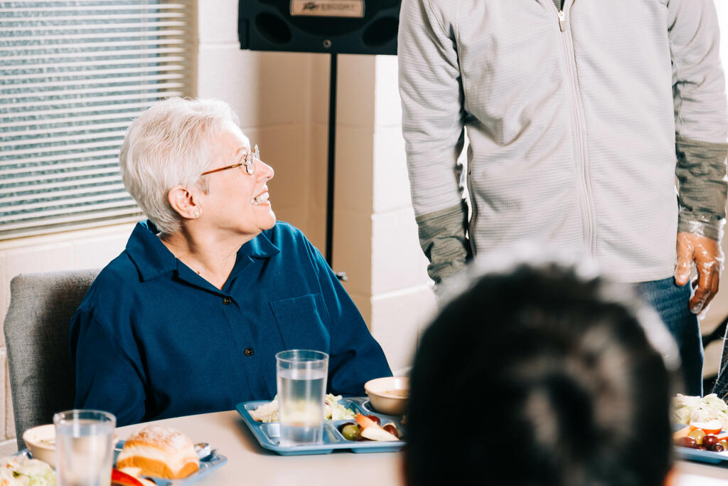 Volunteer Talking to an Elderly Woman at a Community Meal large preview