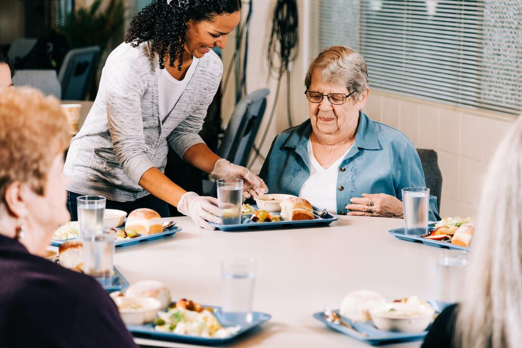 Volunteer Serving a Meal to a Woman at a Community Meal large preview