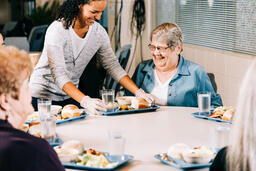 Volunteer Serving a Meal to a Woman at a Community Meal  image 5