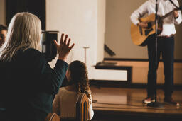 Elderly Woman with Hands Raised During Worship  image 2