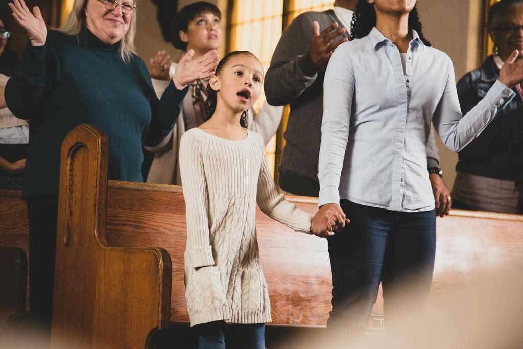 Mother and Daughter Holding Hands During Worship large preview