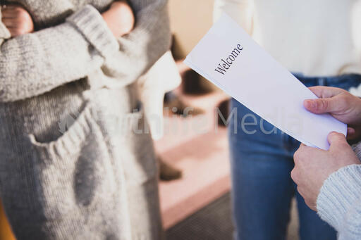 Greeter Holding Welcome Pamphlets
