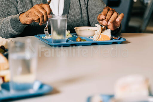 Man Eating at a Community Meal