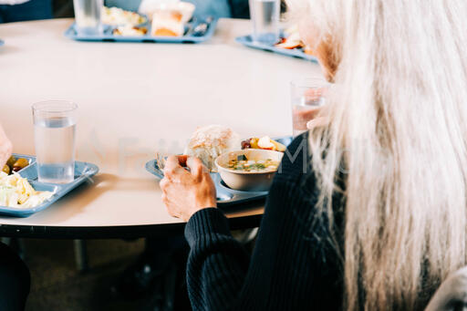 Woman Seated for a Community Meal