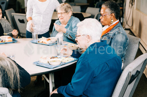 People Laughing Together During a Community Meal