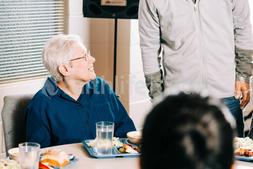 Volunteer Talking to an Elderly Woman at a Community Meal