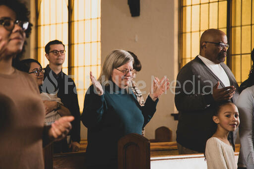 Elderly Woman with Hands Raised During Worship