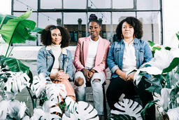 Women Sitting Together Surrounded by Plants  image 3