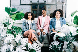 Women Sitting Together Surrounded by Plants  image 1