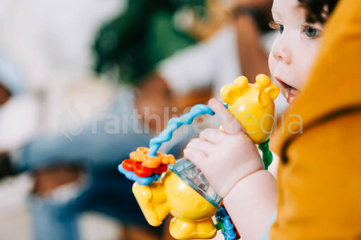 Baby on Mother's Lap Holding a Toy