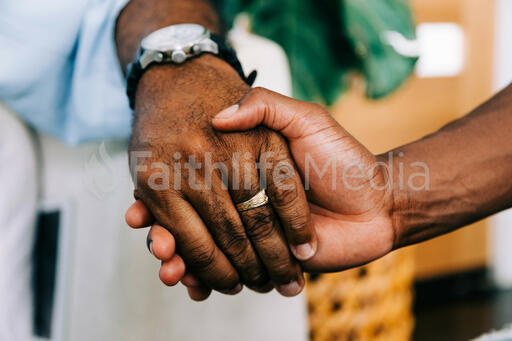 Two Small Group Members Holding Hands in Prayer