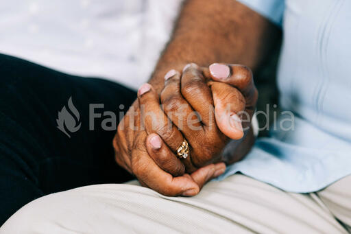 Two Small Group Members Holding Hands in Prayer