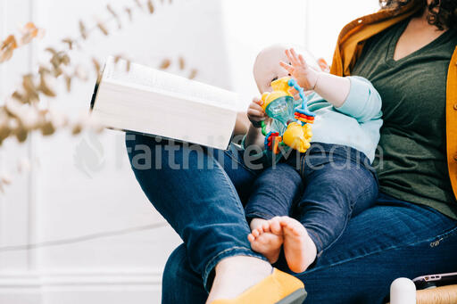Woman Holding Baby and Open Bible