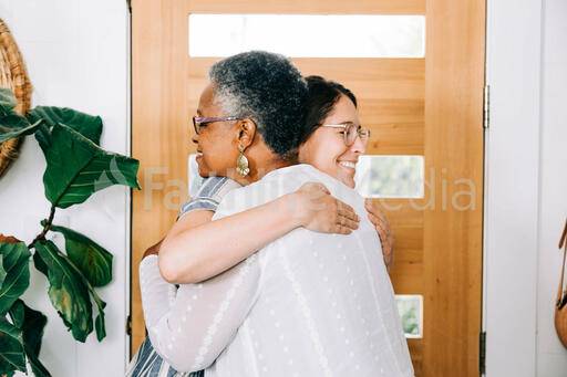 Women Hugging at Entrance of Home before Small Group