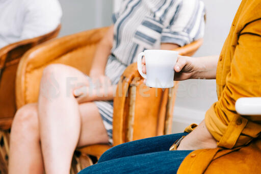 Woman Holding a Cup of Coffee during Small Group