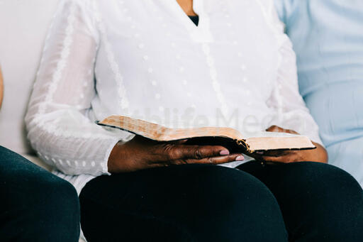 Woman Reading from Open Bible at Small Group