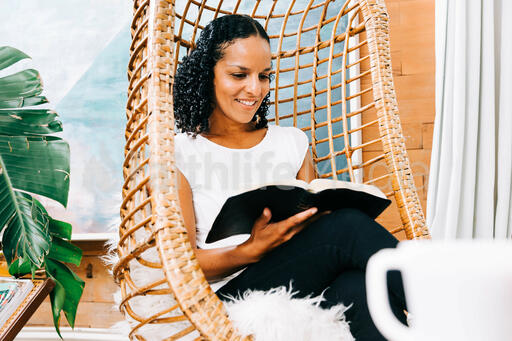 Woman Reading Bible in Living Room
