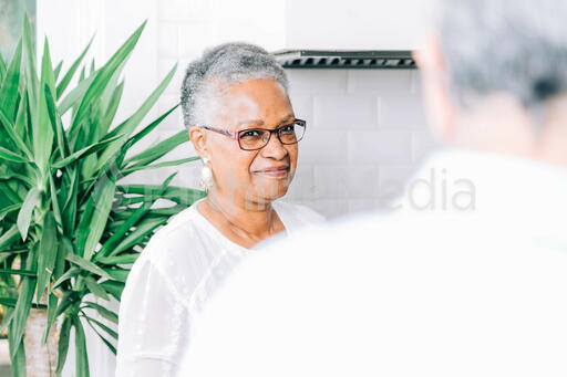Woman Smiling in Conversation in the Kitchen