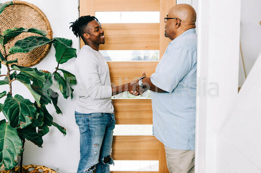 Men Shaking Hands at Entrance of Home