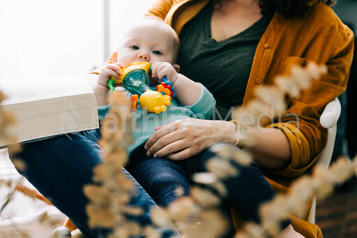 Woman Holding Baby and Open Bible