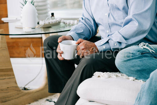 Man Holding Cup of Coffee at Small Group