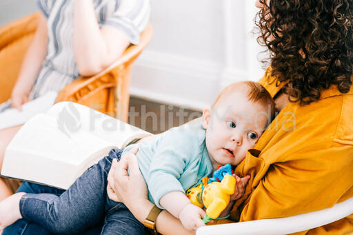 Woman Holding Baby and Open Bible