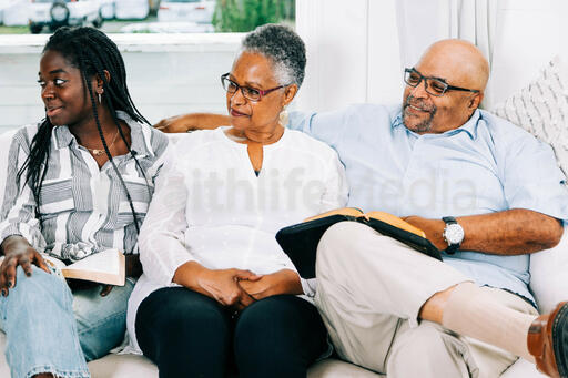 Family Seated Together and Smiling at Small Group