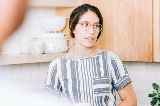 Woman Holding Cup of Coffee and having Conversation in the Kitchen