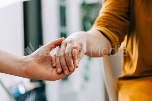 Two Small Group Members Holding Hands in Prayer