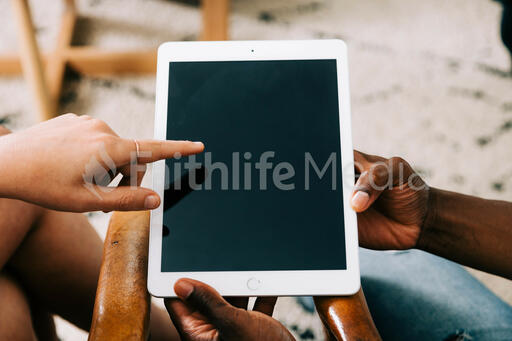 Woman Pointing at Man's iPad Screen