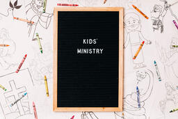 Kids' Ministry Letter Board Surrounded by Crayons and Coloring Pages  image 1